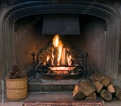 Fotografia Stone fireplace with a lit roaring fire