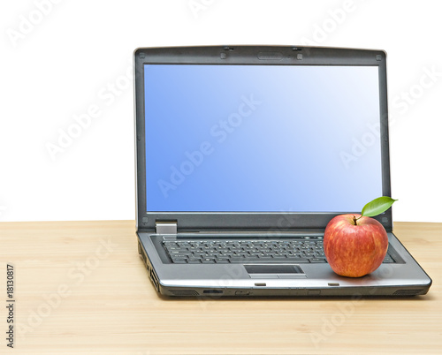 Notebook and apple on desk photo