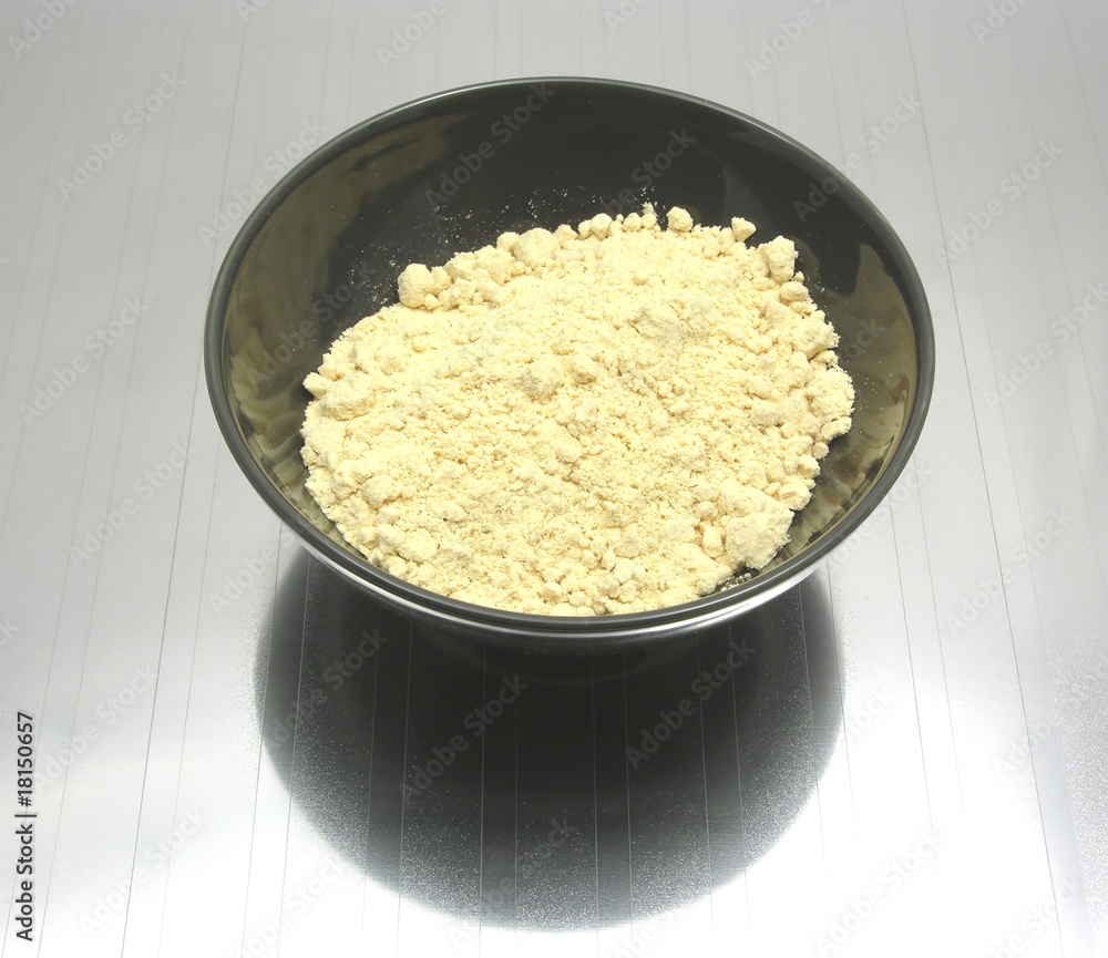 Porzellanschale mit Sojamehl auf spiegelnder Unterlage Porzellanschale mit Sojamehl auf spiegelnder Unterlage