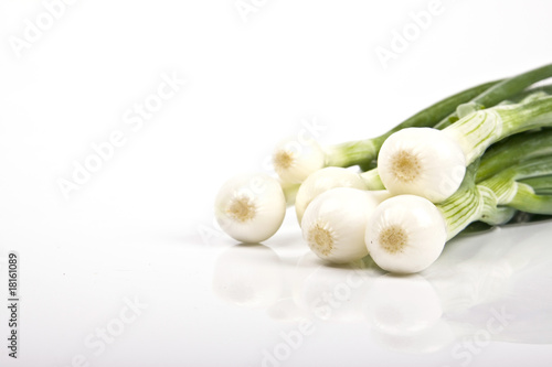 Fresh green garlic standing alone on a white background