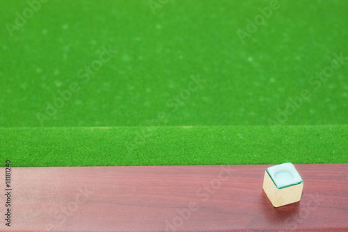 Obraz na plátně Piece of cue chalk on wooden rail with out of focus green baize