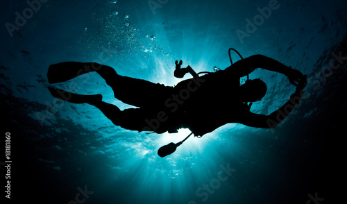 male diver silouette in deep ocean photo