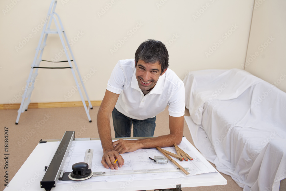 Smiling architect man decorating a bedroom Smiling architect man decorating a bedroom