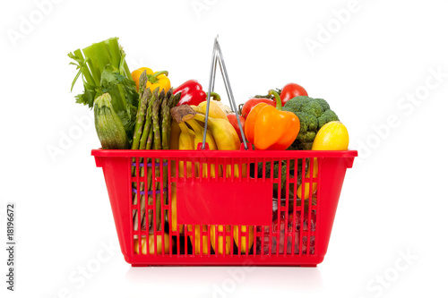 Red shopping basket with vegetables on white