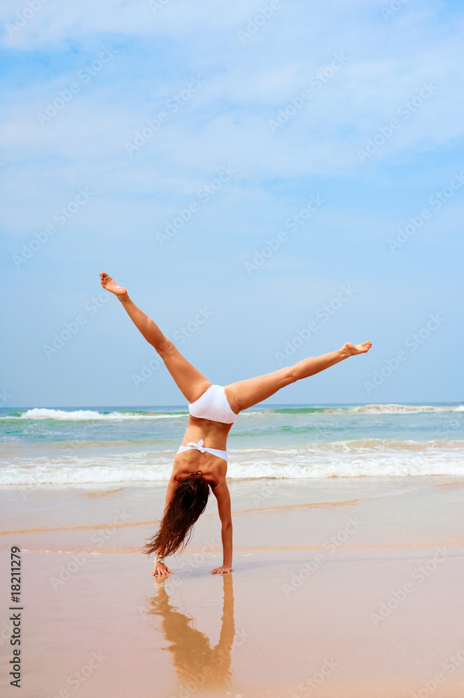 woman doing cartwheel at the beach woman doing cartwheel at the beach