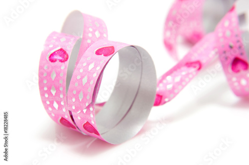 Pink streamer with heart shapes over white background
