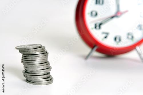 Stack of coins and alarm clock