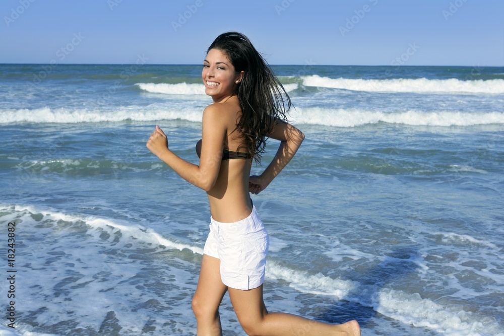 Beautiful summer brunette girl jumping on the beach Beautiful summer brunette girl jumping on the beach