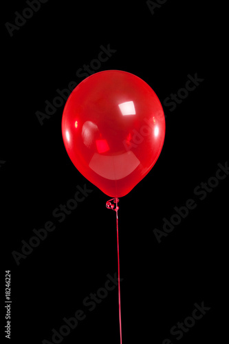 Red party balloon on black
