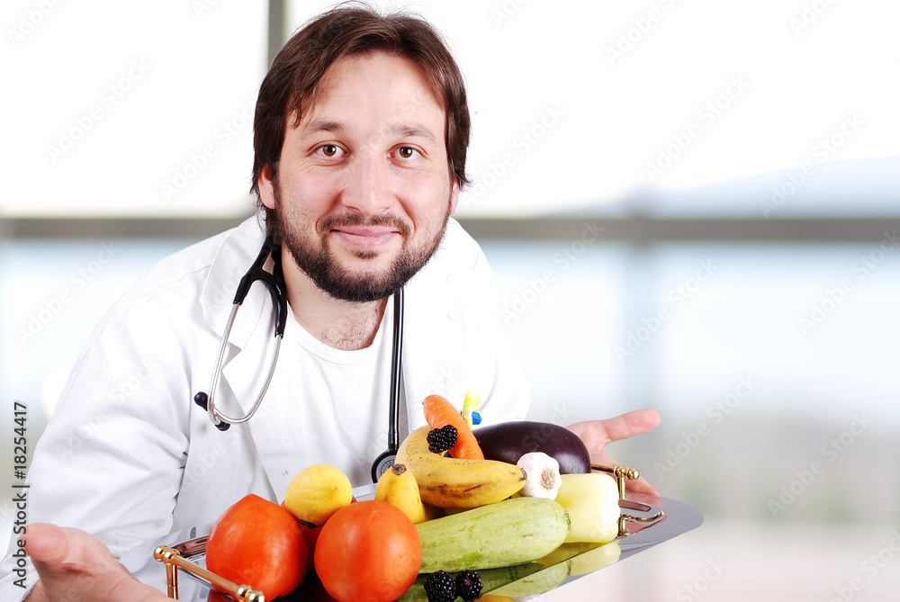 Young doctor in hospital with plenty of fruits and vegetables