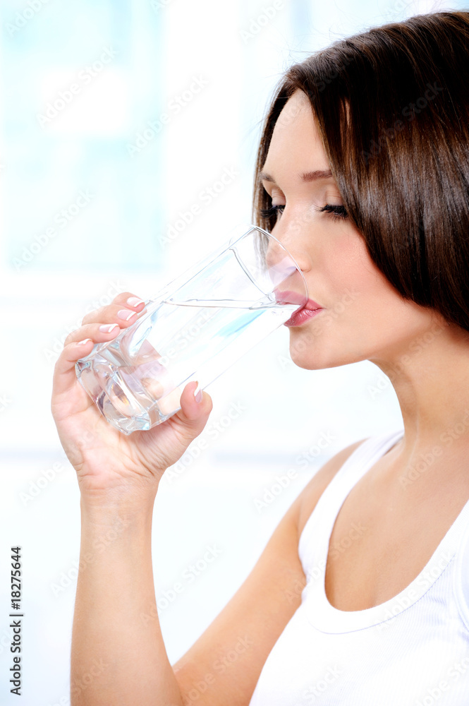 Beautiful girl drinks pure water from a glass Beautiful girl drinks pure water from a glass