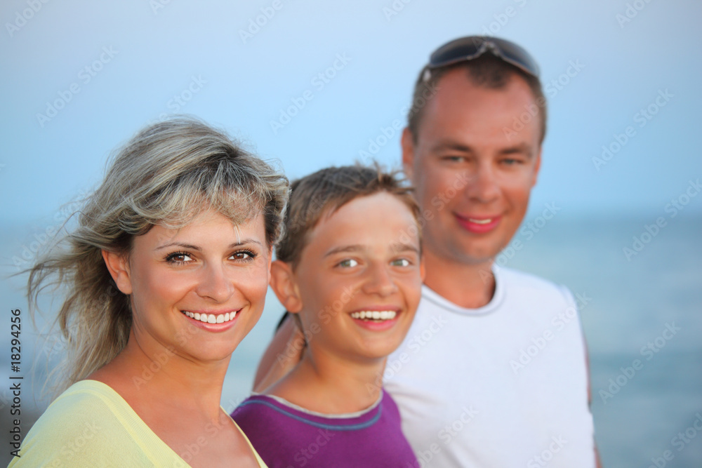 Happy family with smiling boy on beach in evening Happy family with smiling boy on beach in evening