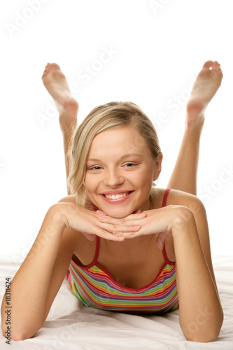 Fotografie Portrait of young happy woman lying on bed