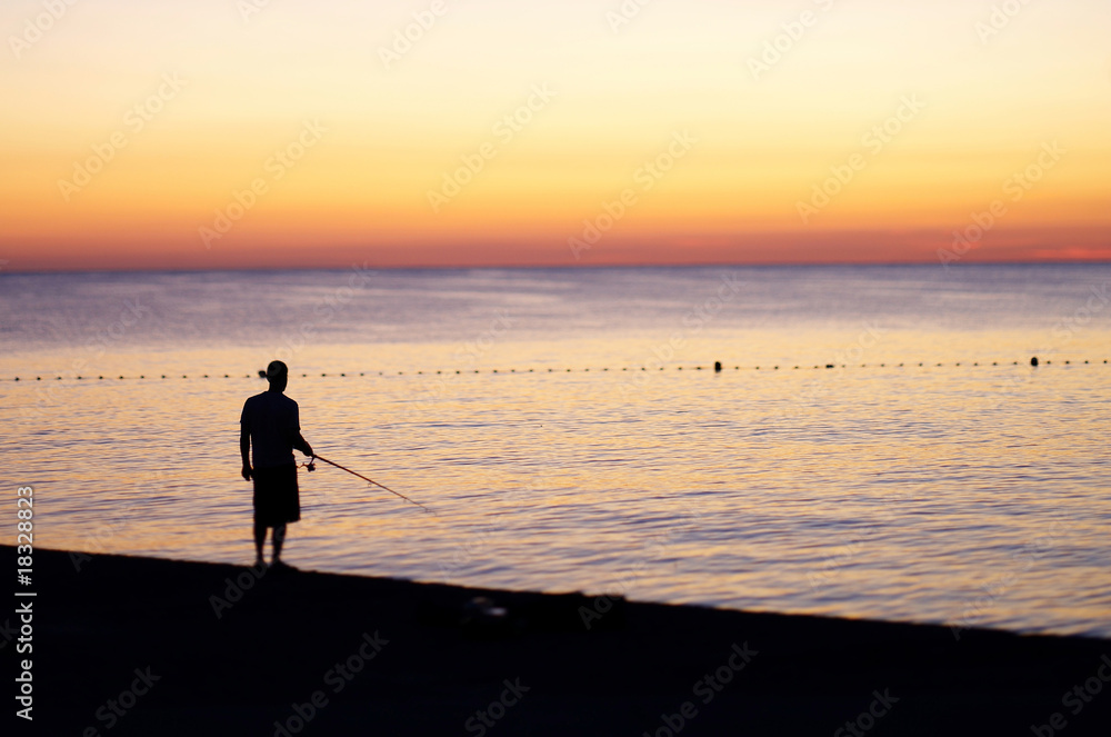 Fisherman is fishing on the beach