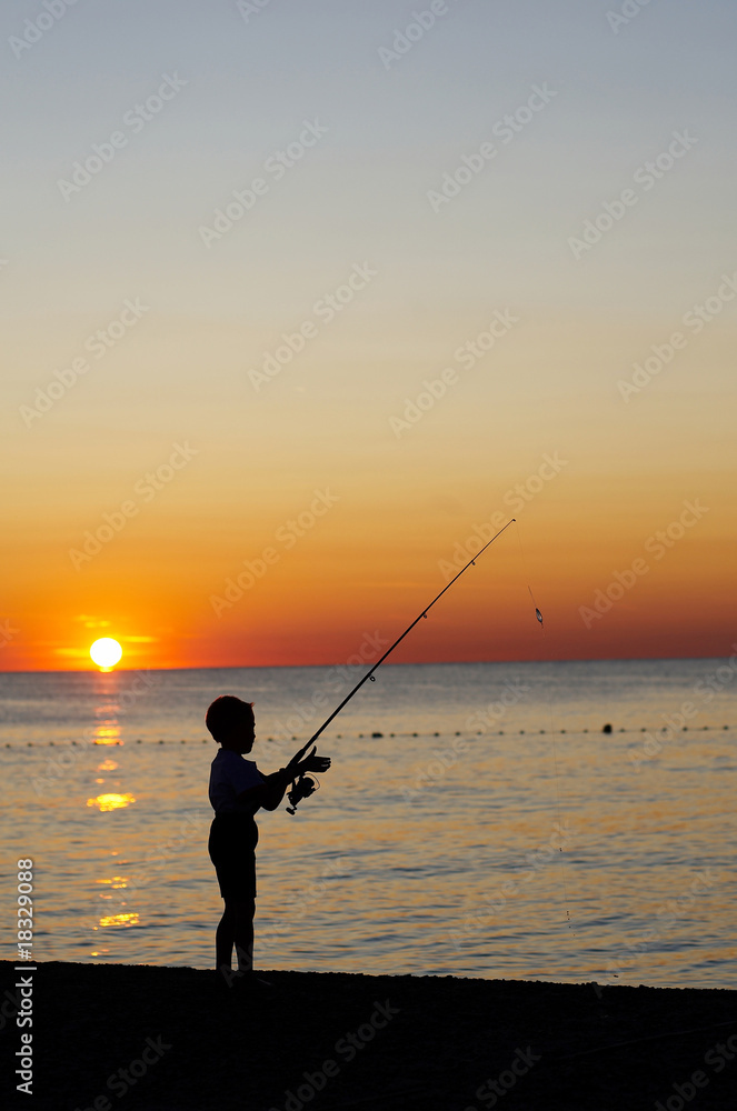 Young boy is fishing on the beach