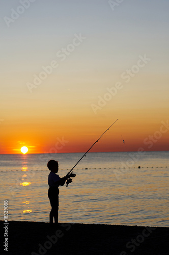 Young boy is fishing on the beach © Tomo Jesenicnik