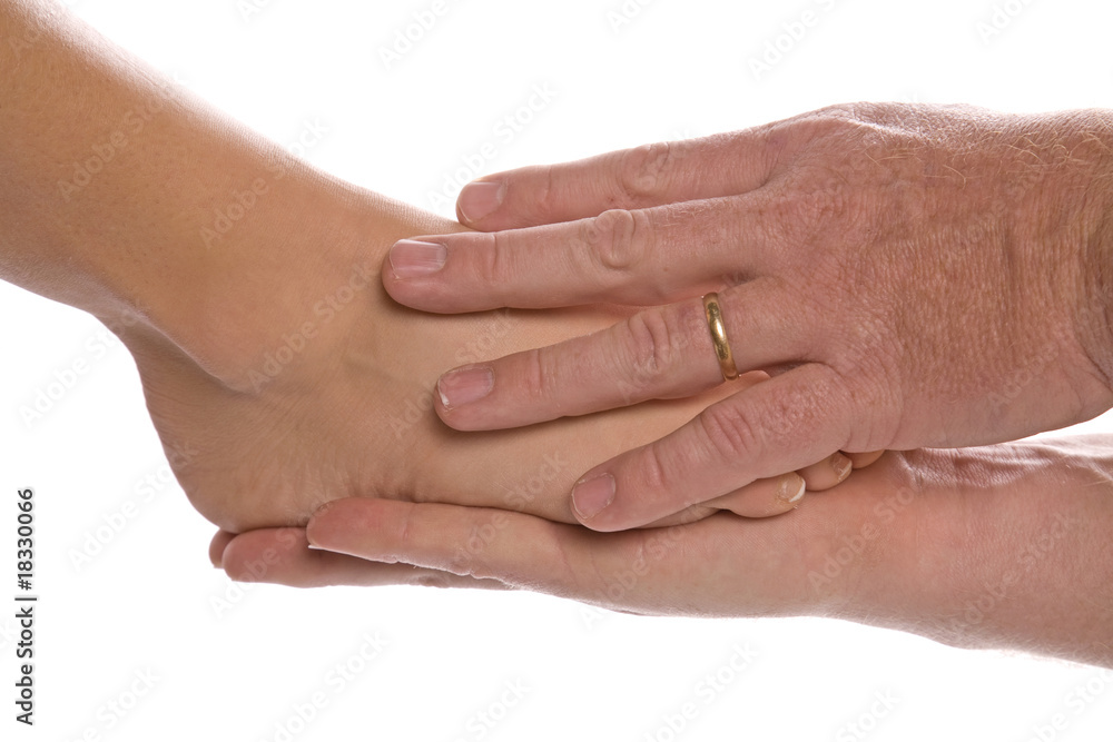 Fototapeta premium Womans foot in mans hands