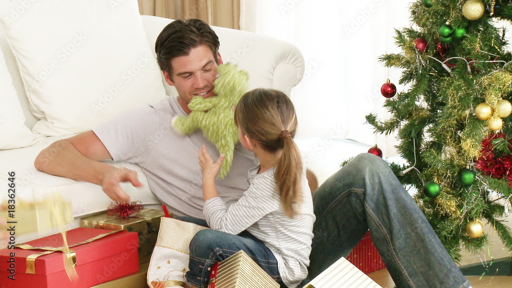 Father and daughter having fun with a Christmas gift Father and daughter having fun with a Christmas gift