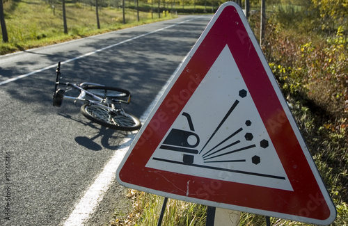 bike accident on road with trees and street signal