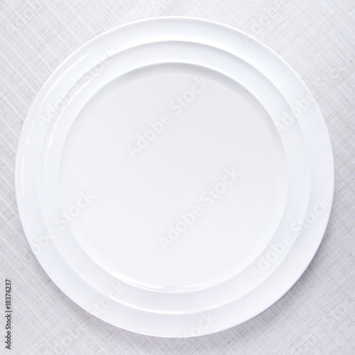 Empty white plate on tablecloth