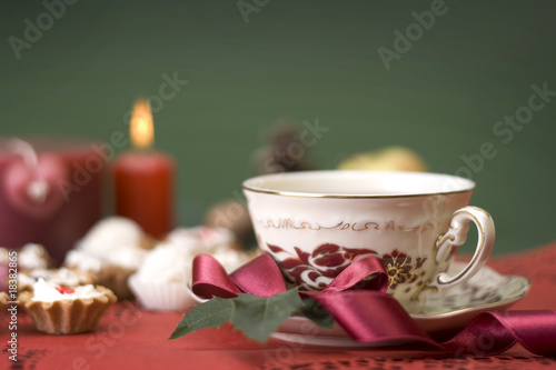 hot cup of tea with ribbon, cookies and candle