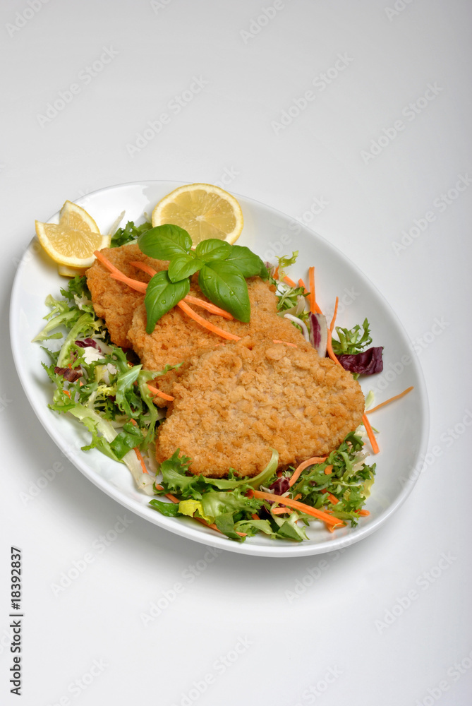 breaded fish steak with organic herbs on a plate breaded fish steak with organic herbs on a plate