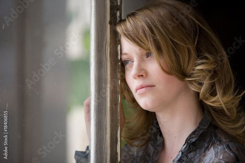 Frau schaut traurig aus dem Fenster