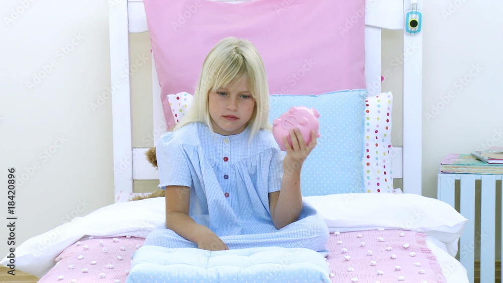 Little girl playing with a piggy bank Little girl playing with a piggy bank