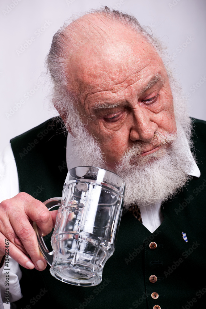 Bavarian man, looking surprised at his empty beer Bavarian man, looking surprised at his empty beer