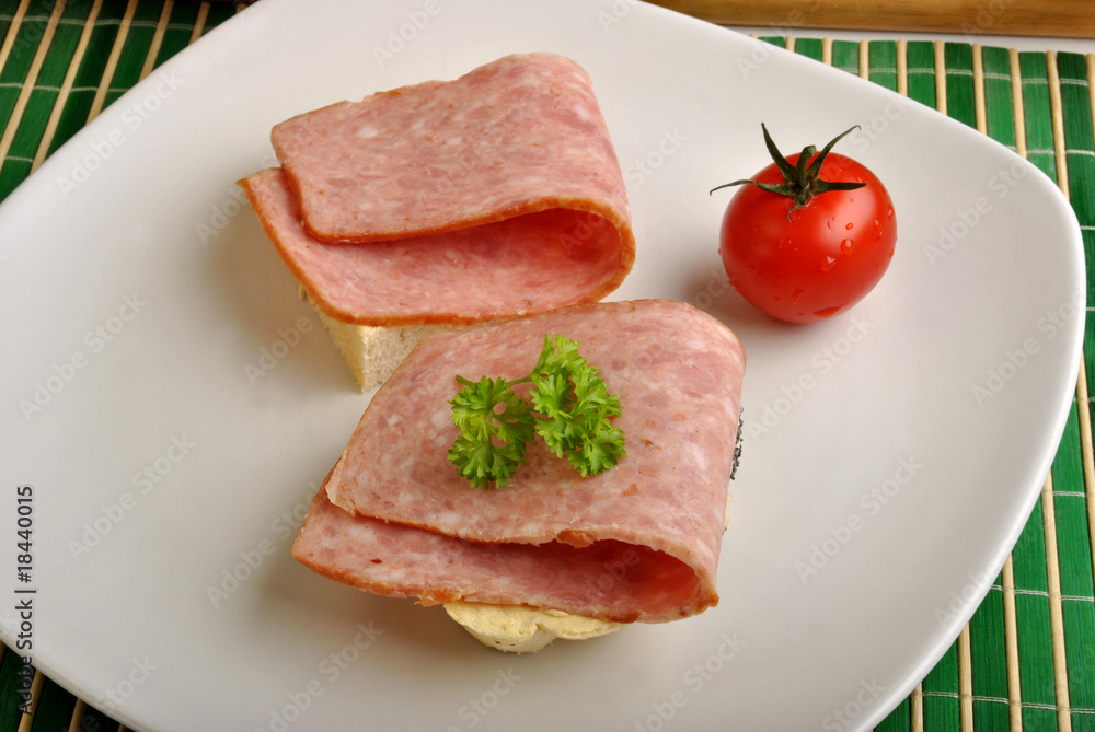 half bread roll with ham on a plate