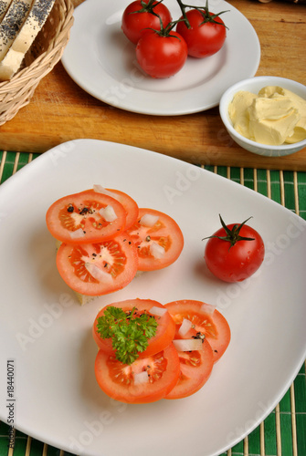 half bread roll with tomato on a plate