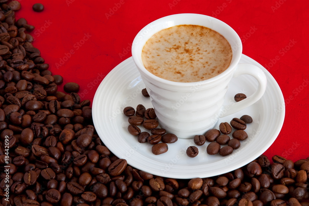 cup with coffee and grain expressed on red background