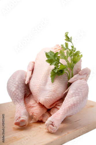 crude chicken on chopping board. It is isolated.