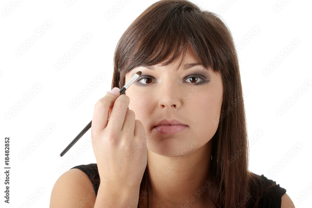 Woman in elegant black dress does a make up Woman in elegant black dress does a make up