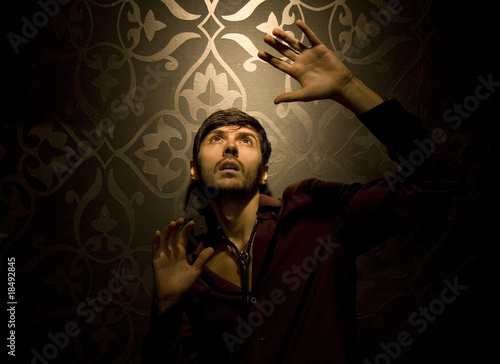 Studio photo of model in the spotlight looking up with fear/awe photo