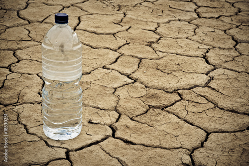 Water bottle on dry ground photo