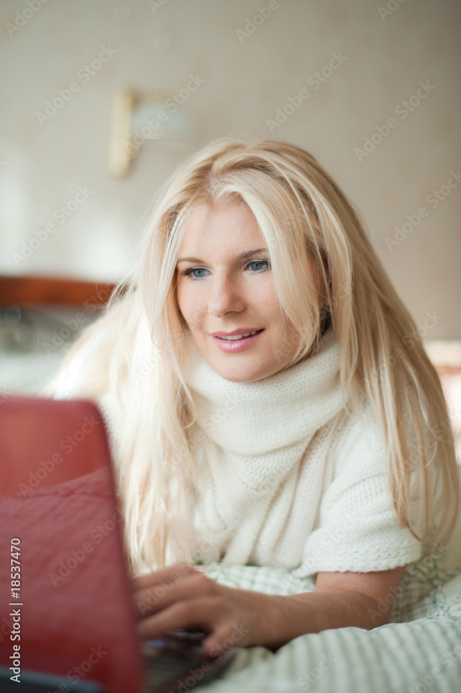 Young sexy woman relaxing with laptop on a bed Young sexy woman relaxing with laptop on a bed