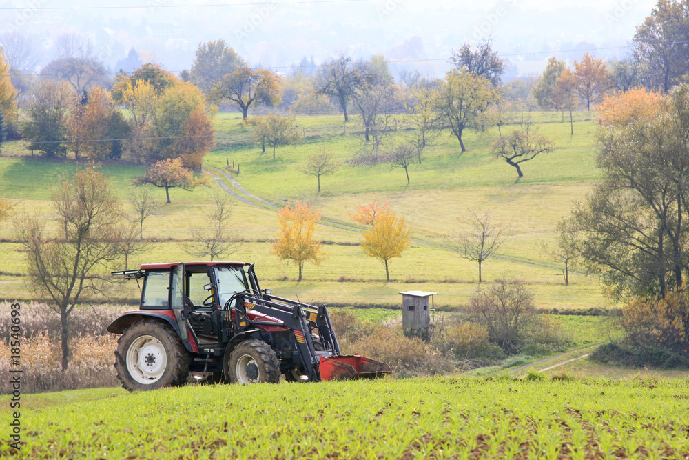 Fototapeta premium Traktor steht in der Landschaft