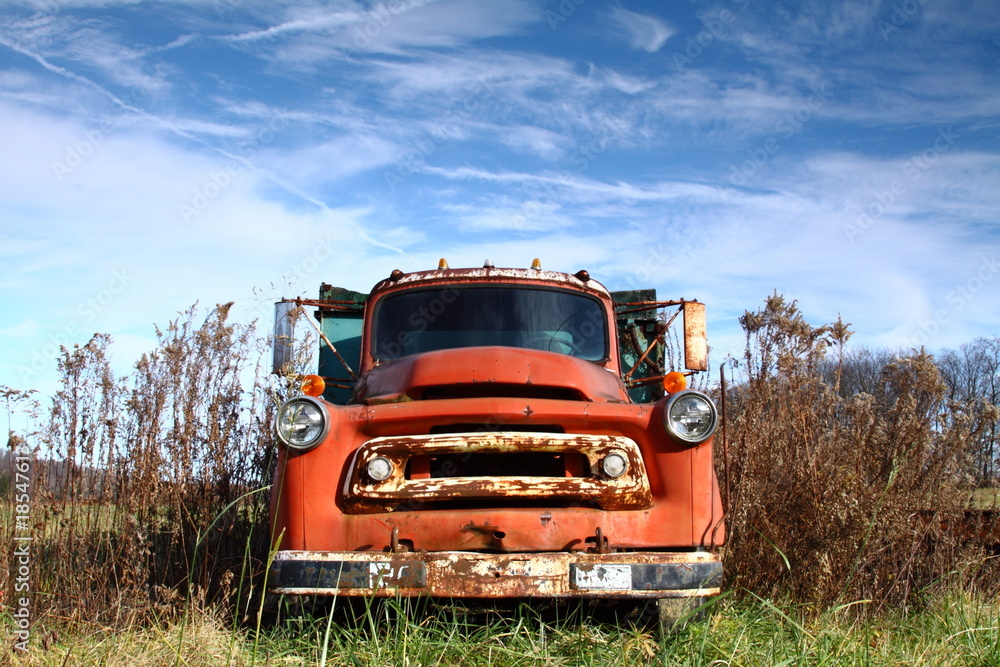 Old Dented Pickup in Field with Blue Sky