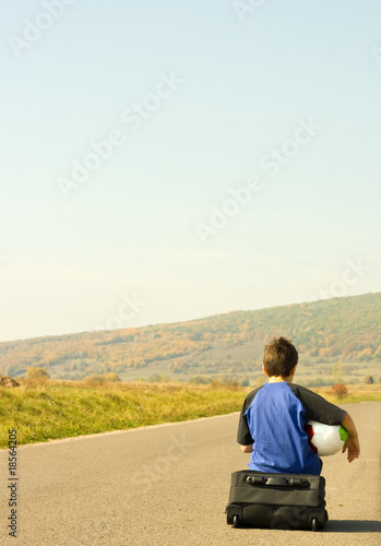 Young boy hitching on road