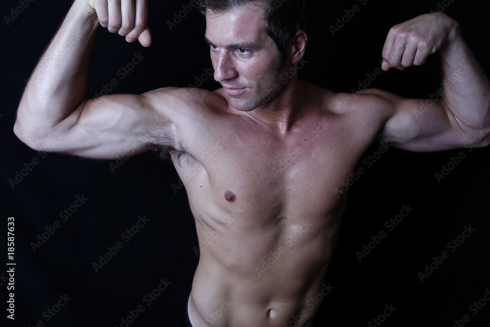 Portrait of sexy muscular man showing his biceps