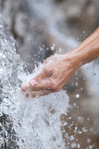 detail of femalw hands refreshing at small clear mountain waterf