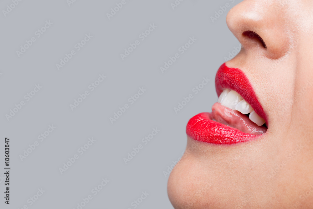 Naklejka premium Close up woman licking her red teeth.