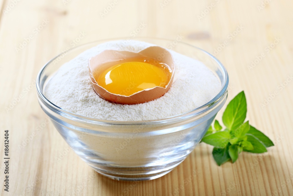 Fresh egg in a bowl of flour Fresh egg in a bowl of flour