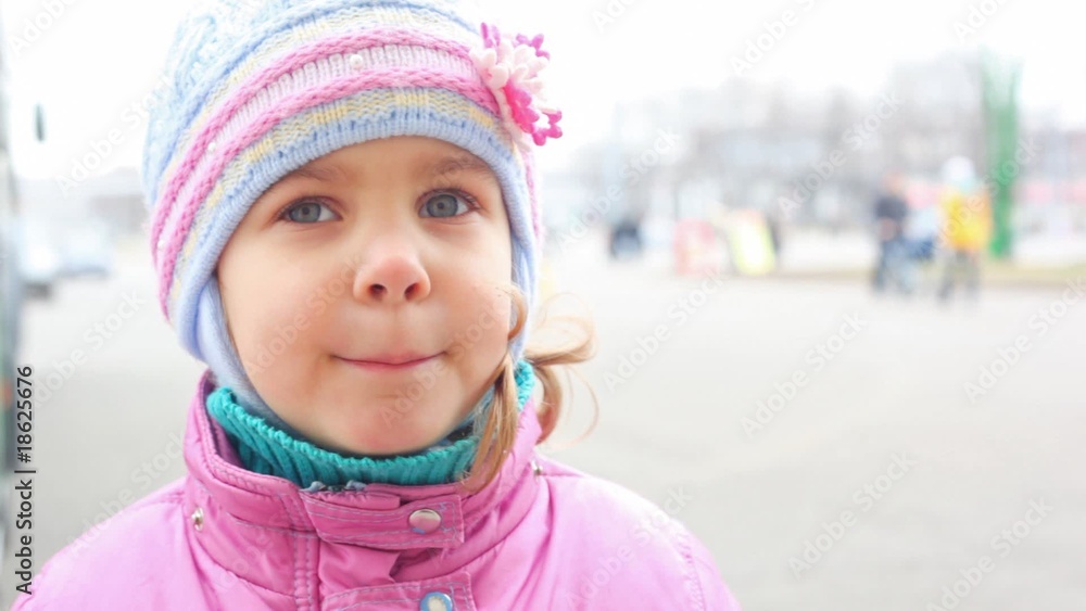 face of small girl standing on street, people walking by face of small girl standing on street, people walking by