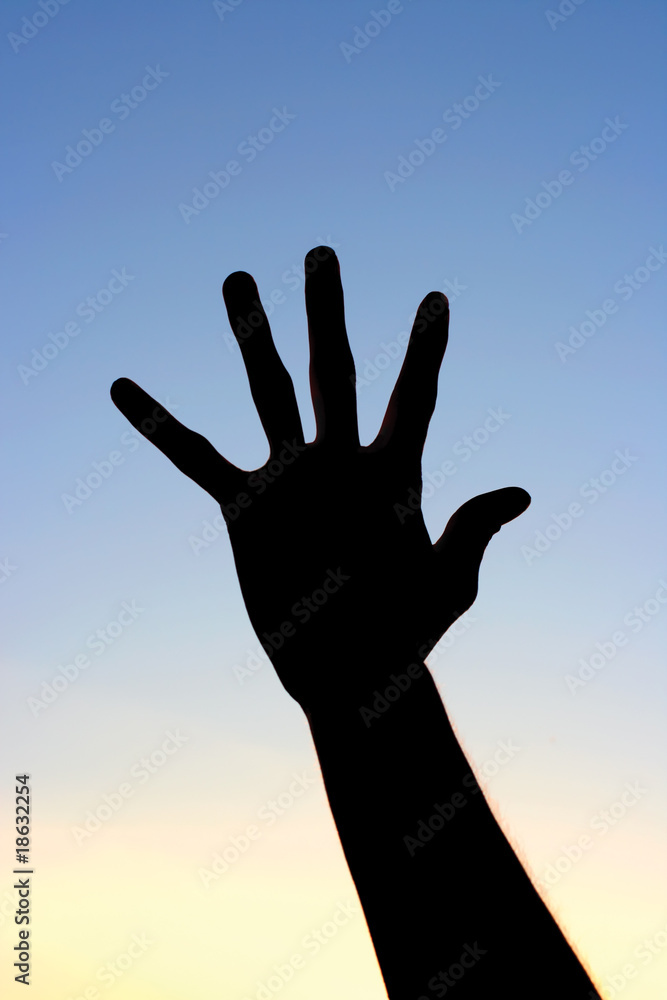 Silhouette of a hand against a sky
