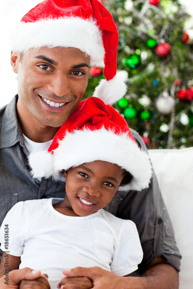 Afro-American dad and daughter wearing a Christmas hat Afro-American dad and daughter wearing a Christmas hat