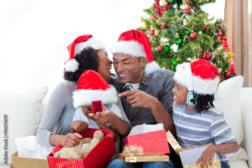 Happy Afro-American family having fun with Christmas presents