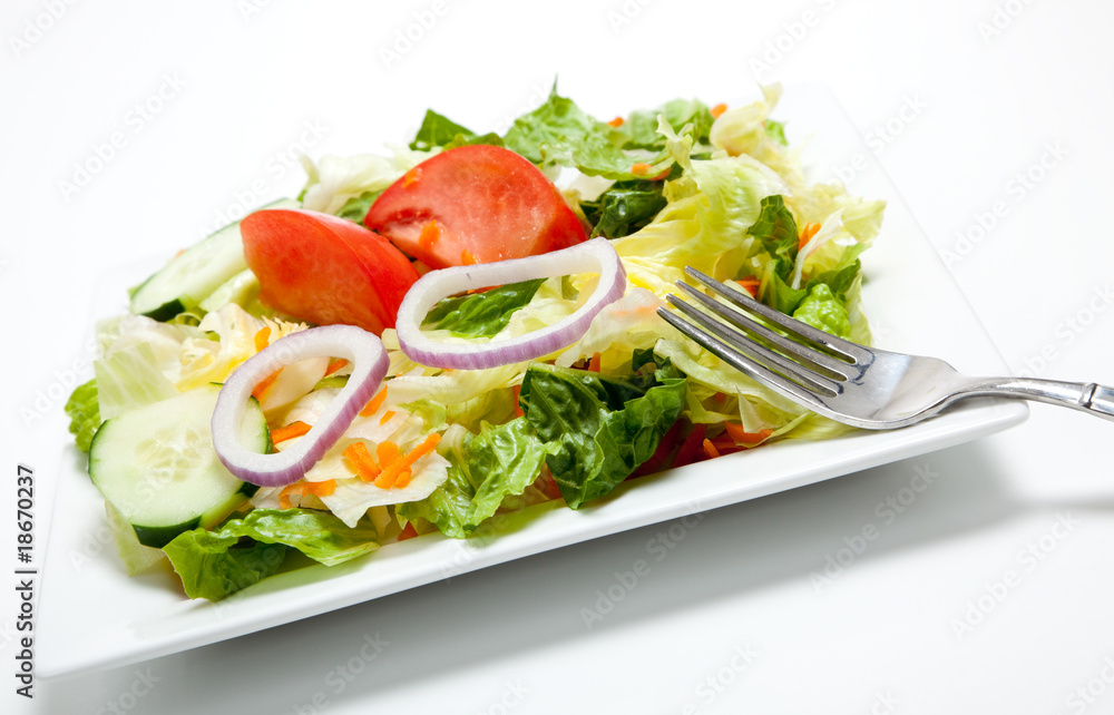 Tossed salad on a plate on a white background Tossed salad on a plate on a white background