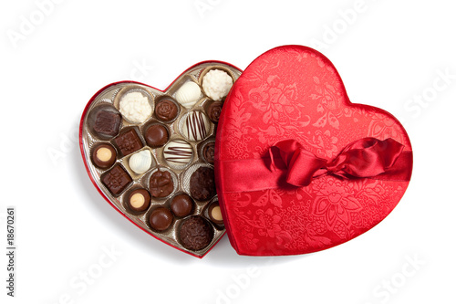 Red heart full of chocolates on white